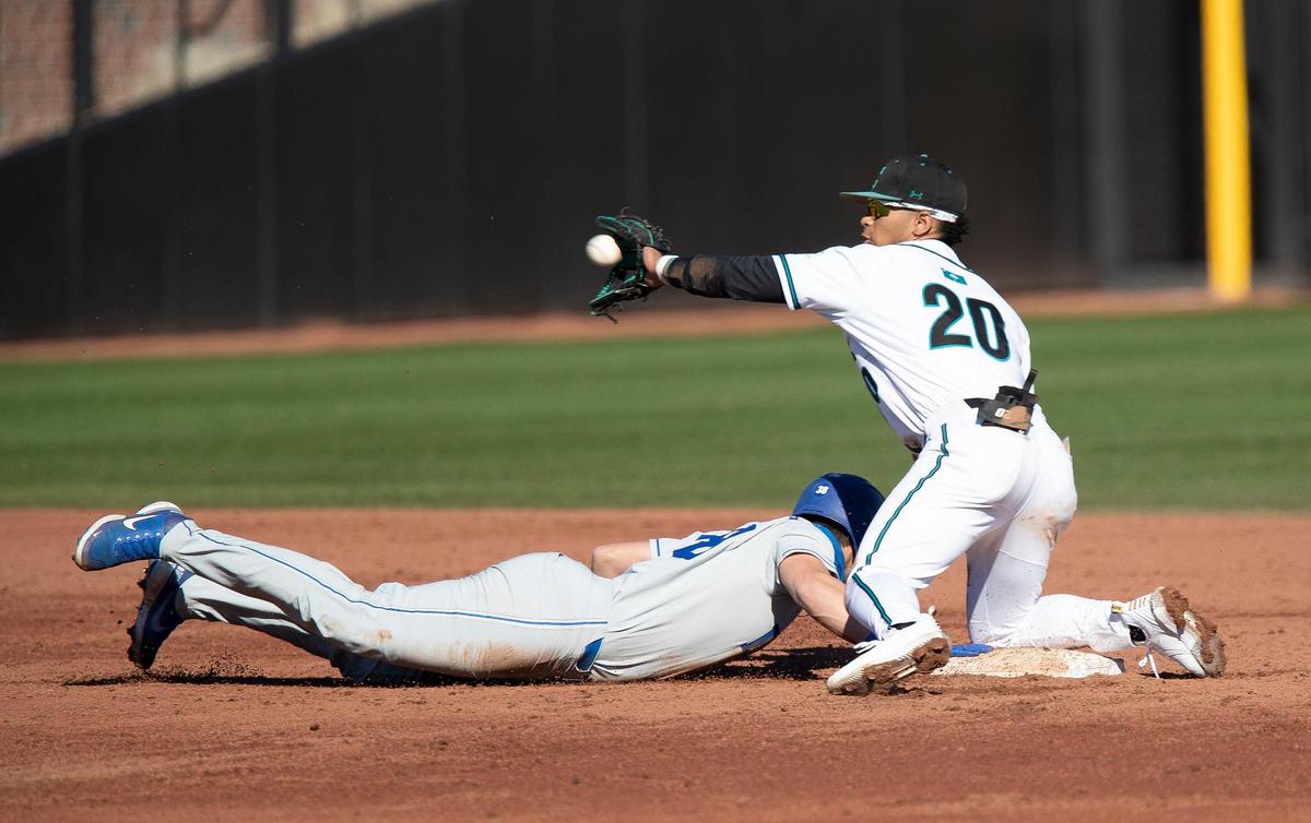Coastal Carolina infielder Eric Brown (20) tries to tag out Duke’s Michael Rothenberg (38) on Feb. 20, 2021 at Springs Brooks Stadium in Conway.