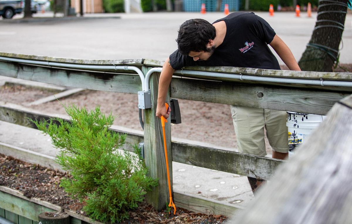 Remington Scott of Surfside Beach reaches down to grab trash left over from Thursday evening’s July 4 festival at the Murrells Inlet MarshWalk.