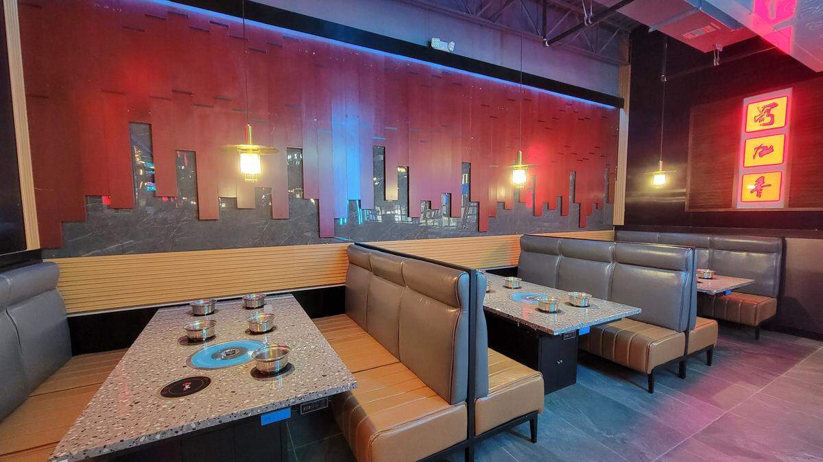 Tables for cooking hot pot and Korean-style barbecue at Nine Spices Hot Pot and BBQ.