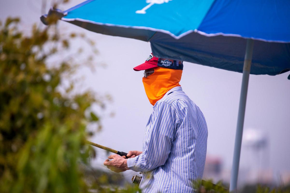 Wearing a facemask, a fisherman fishes from shore at the Cherry Grove Park on Tuesday. Locals around the Grand Strand were enjoying the Spring weather on Tuesday by getting outside. South Carolina’s Governor Henry McMaster toughed his “work or stay home” order this week In response to the coronavirus, but he made allowances for recreational activities. April 6, 2020