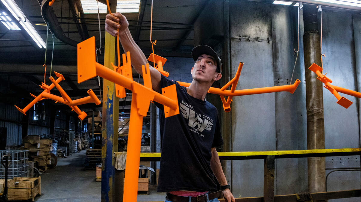 Cody Kite moves freshly powder coated Worksman Cycle frames for heat curing. Worksman Cycles, a manufacturer of industrial bicycles and tricycles that are primarily used in large factories, but also have recreational uses, was founded in 1898. The company is considered the oldest U.S. made cycle manufacturer. Factory operations moved from New York City to Conway, S.C. in 2016. March 7, 2023.