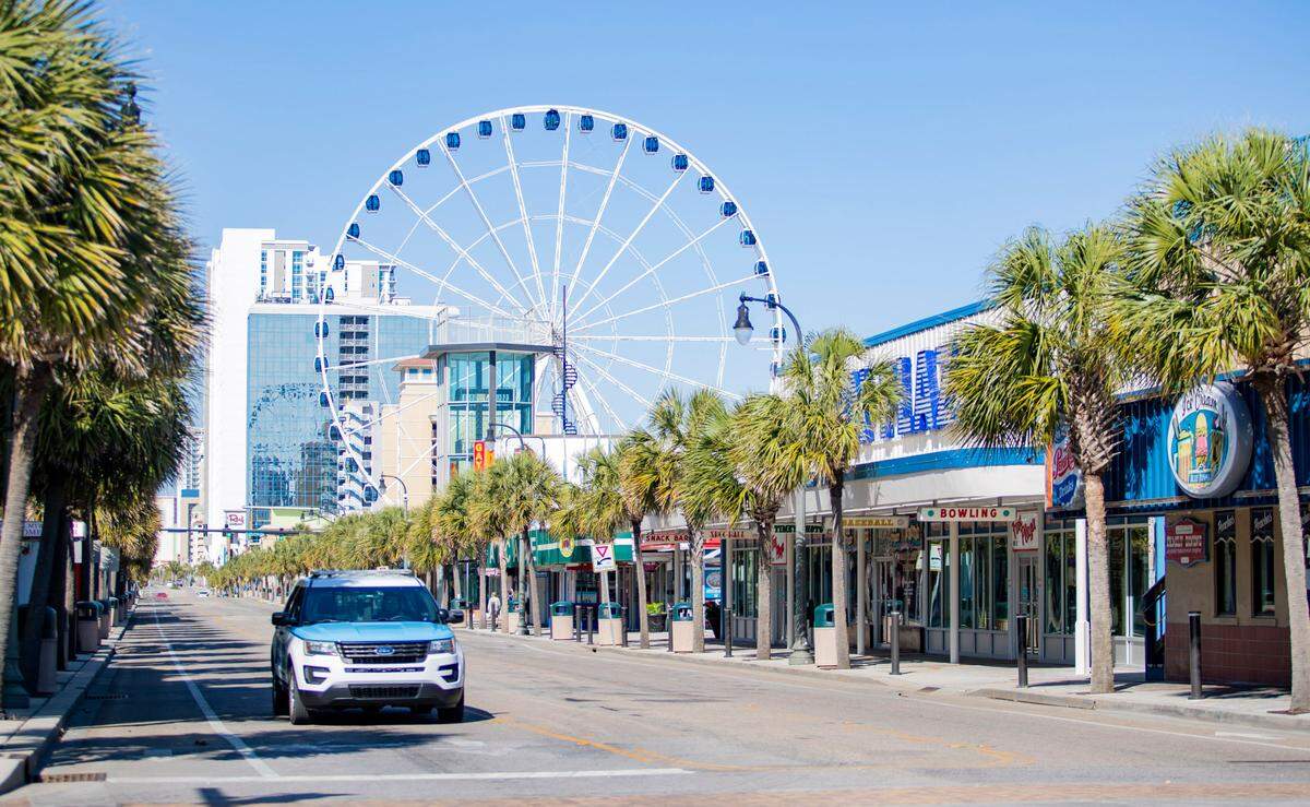 A Myrtle Beach police officer drives along Ocean Boulevard Friday afternoon as COVID-19 coronavirus cases continue to surface in Horry County.
