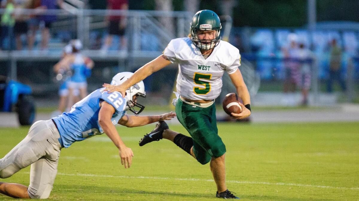 West Florence senior quarterback Cooper Wallace scrambles as the Knights take on the St. James Sharks Monday night in Murrells Inlet.