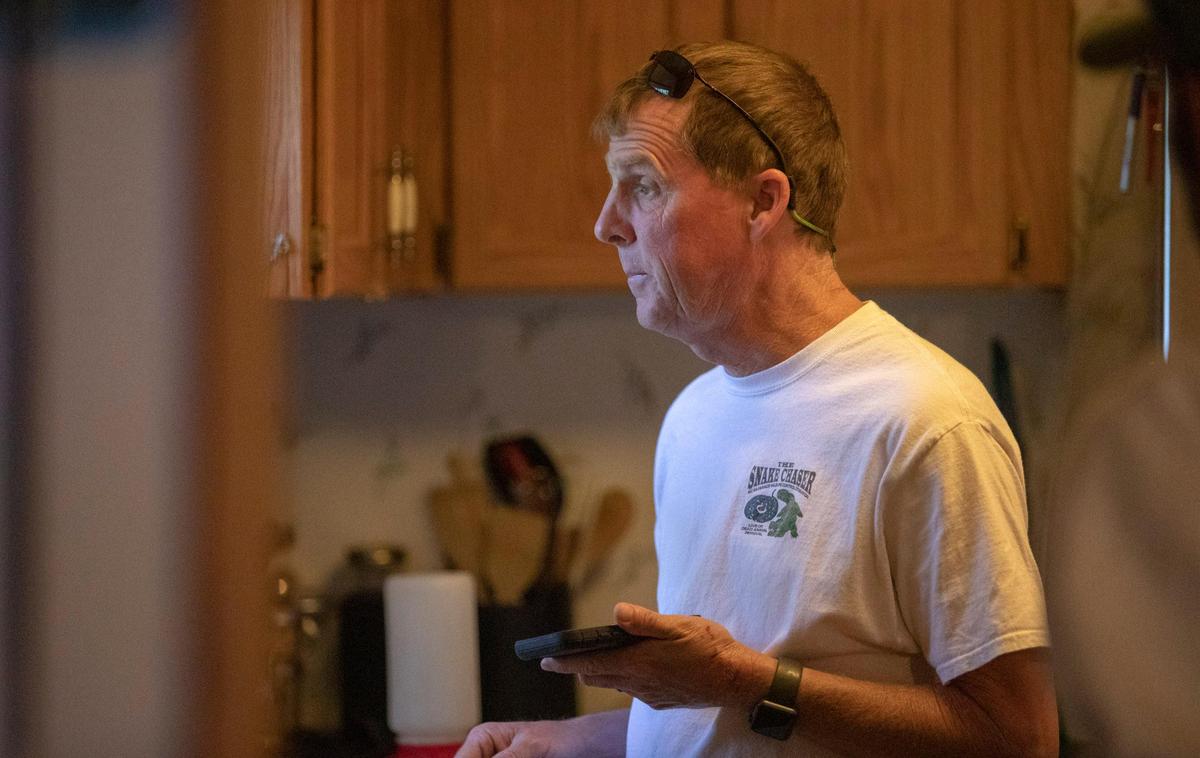 Snake Chaser Russell Cavender looks out the window of his office in Longs Wednesday morning before beginning a morning meeting with his team.