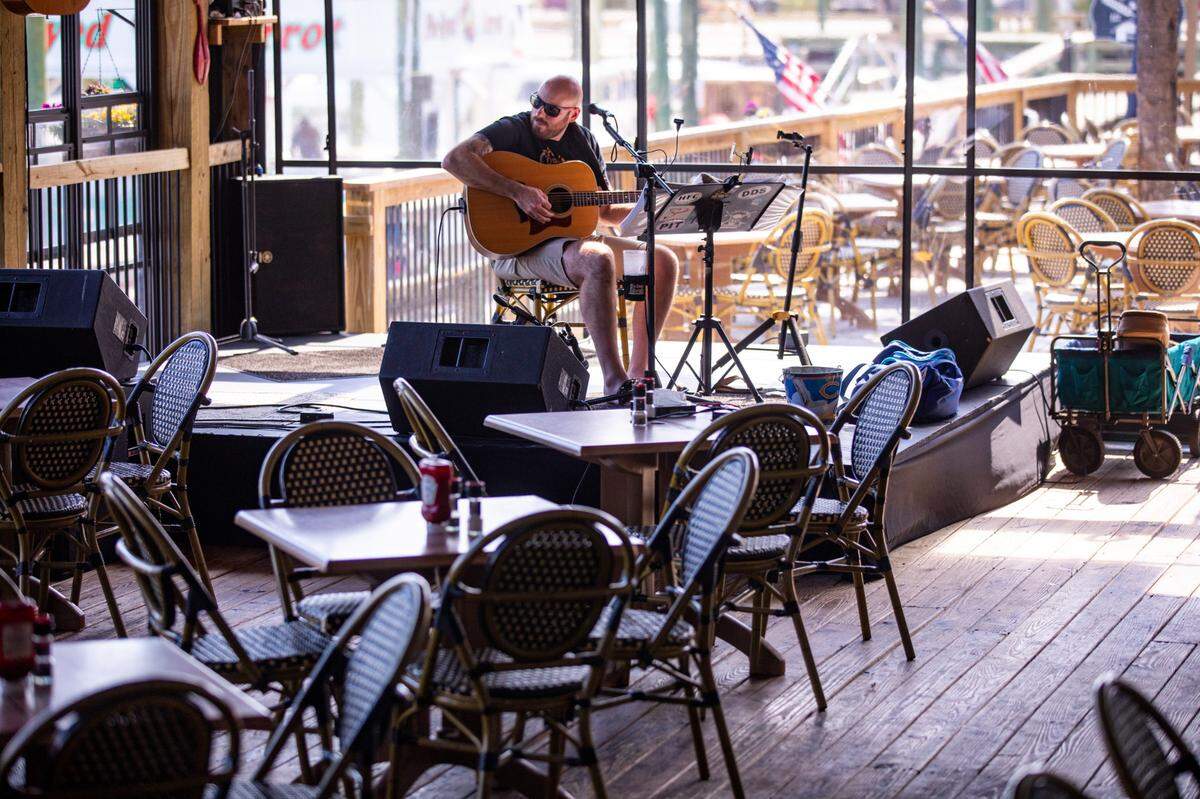Nicholas Andolora plays for to an empty dining room Dead Dog Saloon where performances are being streamed live over Facebook despite the shutdown. Local area restaurants and bars around Myrtle Beach are getting creative to try to cope with the coronavirus shut down of eat-in dining. March 19, 2020.