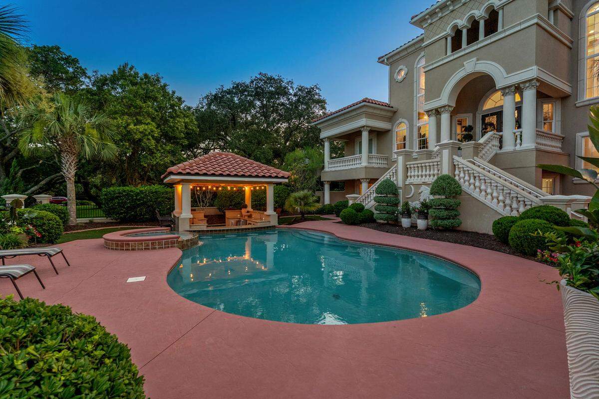 The in-ground pool connects to the outdoor bar area.