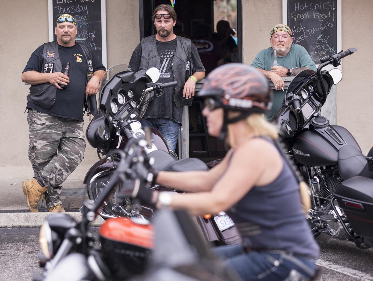 Bikers watch a female bike pass at Captain Archies bar in North Myrtle Beach. Bikers rumbled throughout North Myrtle Beach today visiting vendors at Barefoot Landing, the Harley Davidson store and many of the entertainment venues for Harley Week 2018. May 17, 2018.