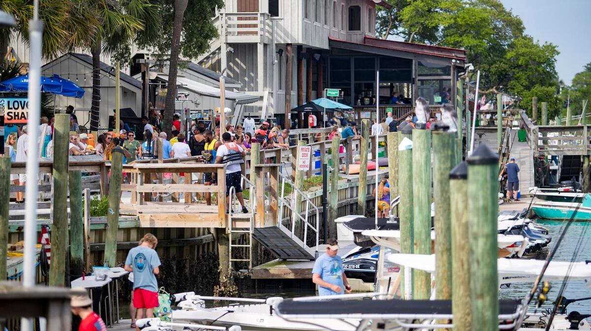 People walk along the MarshWalk in Murrells Inlet Sunday afternoon as Memorial Day weekend crowds grow despite the ongoing coronavirus pandemic.