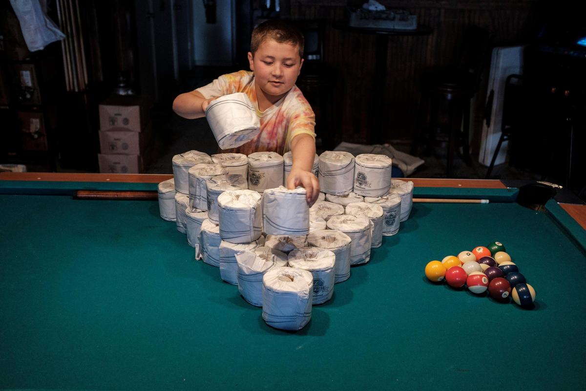 Dylan Thomas Allander, son of Socastee Station owner T.J. Allander, stacks rolls of toilet paper to hand out free with food orders. Local area restaurants and bars around Myrtle Beach are getting creative to try to cope with the coronavirus shut down of eat-in dining. March 19, 2020.