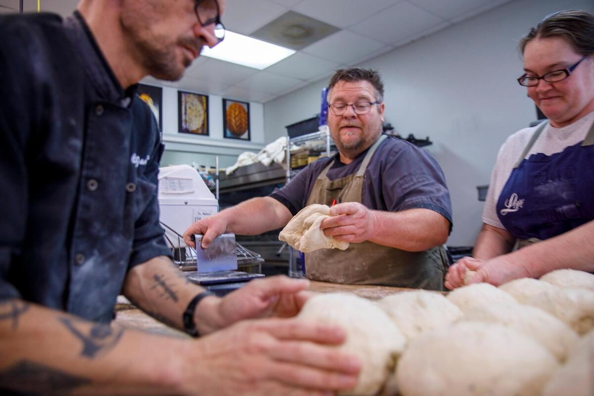 James Levy, left, and partners Chef Geoff Blount and Audrey Brletich roll balls of dough for baking. Leve’ Bakery prepares sour dough bread for their retail shop and farmers market. They prepare 50 to 60 loaves a day. Oct. 23, 2024.