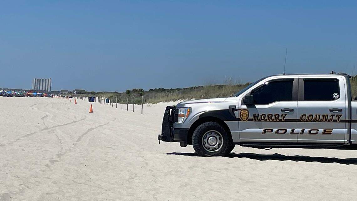 An Horry County Police truck sits on the beach where a beachgoer was struck by a beach patrol vehicle near the Nash Street beach access outside Myrtle Beach, SC. The woman later died. June 14, 2024