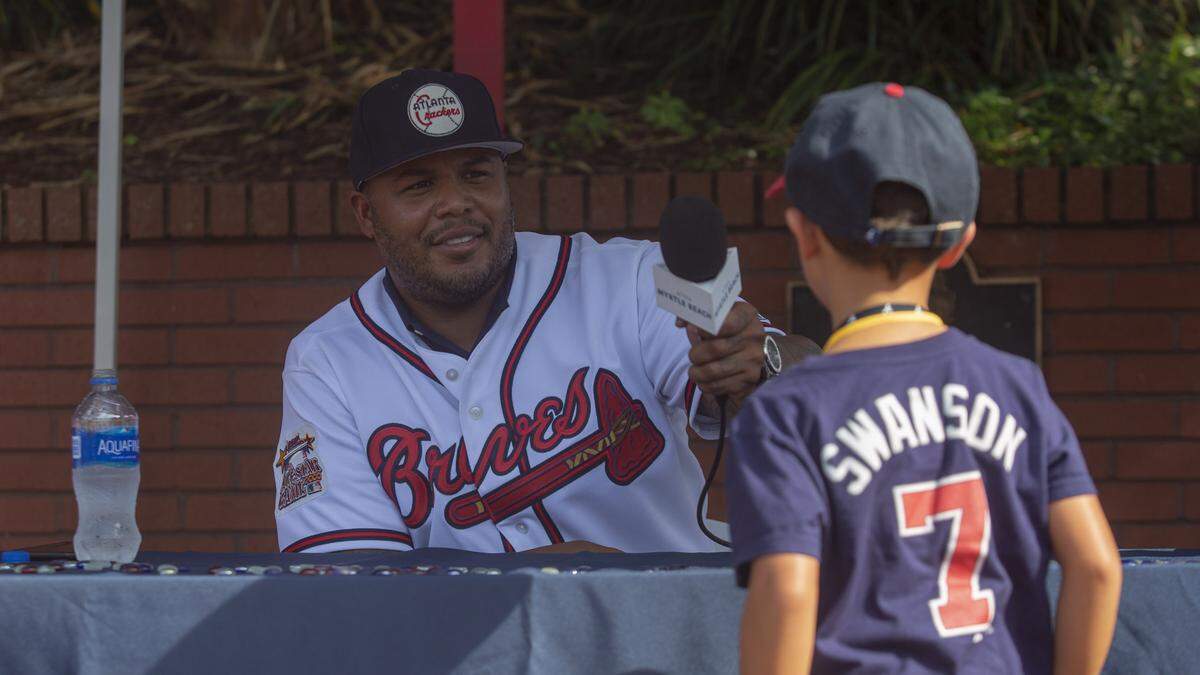 Former Atlanta Braves center fielder Andruw Jones answers a question from 4-year-old Andruw Joines of Raleigh, North Carolina at TicketReturn.com Field at Pelicans Ballpark during the Pelicans' "Braves Weekend" on July 21 in Myrtle Beach.