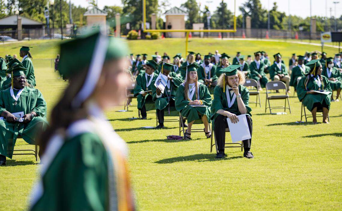 Conway High School seniors sit along the school’s football field during Conway’s 2020 commencement ceremony on the morning of June 2, 2020.