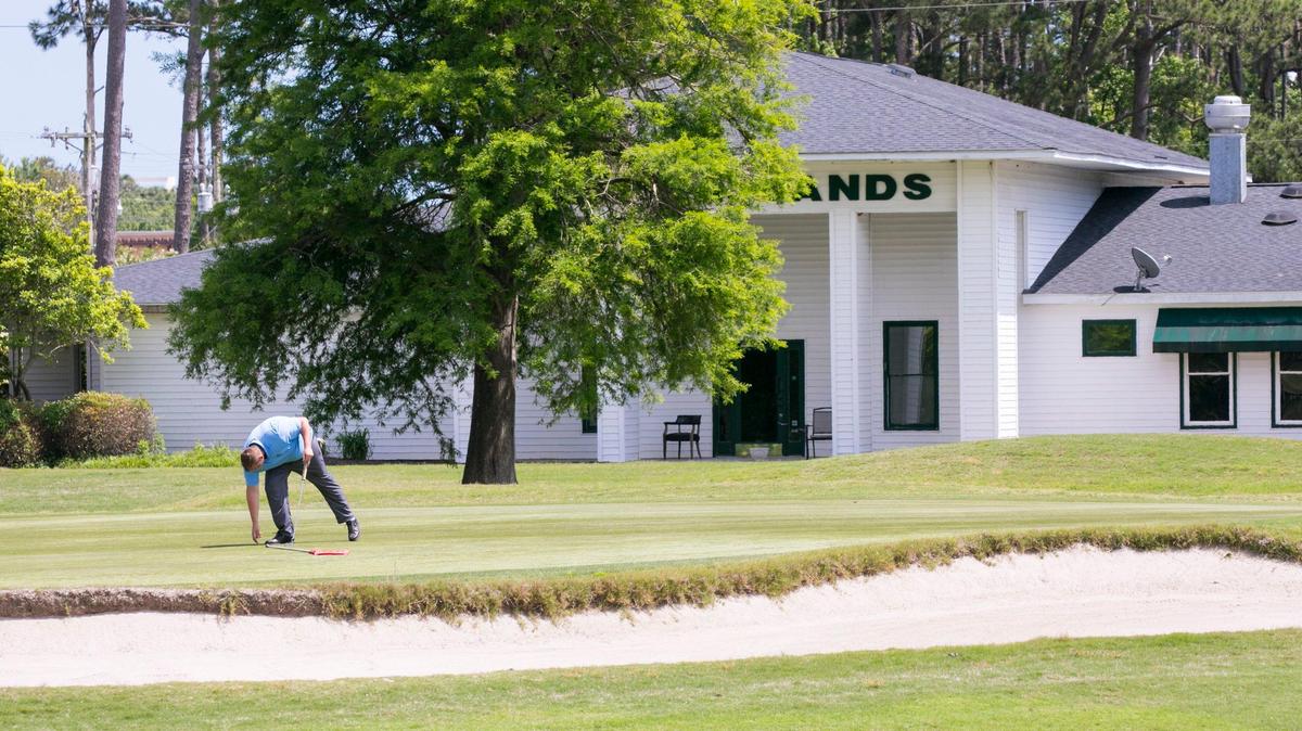 Travis Raynor, the head golf professional, pulls a putt from the cup at Azalea Sands Golf Club. The coursre in North Myrtle Beach is now being managed by the owner and management of Eagle Nest Golf Club. The clubhouse and course are undergoing renovations this summer. May 7, 2019.
