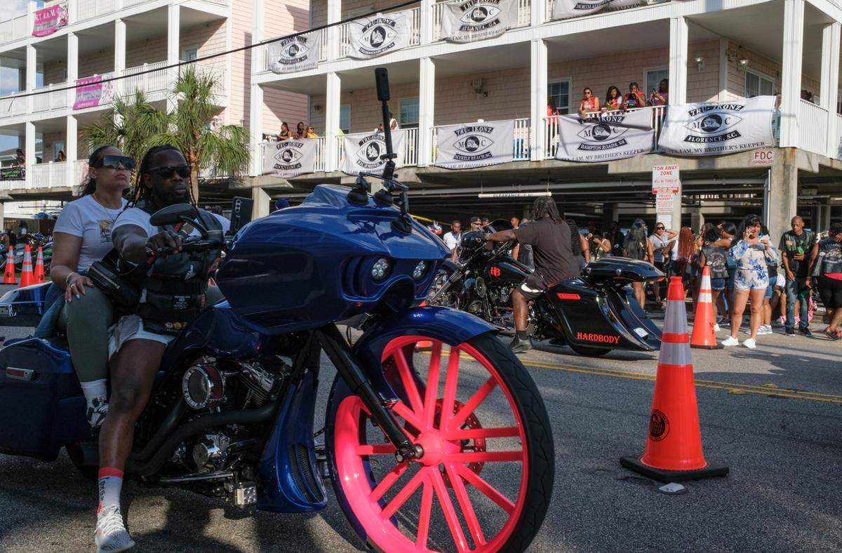 A biker rides past a house party in North Myrtle Beach on Friday. The 2024 Black Pearl Cultural Heritage and Bike Festival, also known as Black Bike Week, came roaring into the Northern end of the Grand Strand Friday night. Bikers gathered at the Myrtle Beach Mall to show off their rides, cruised through Atlantic Beach, and partied under beach houses in North Myrtle Beach. S.C. May 24, 2024.