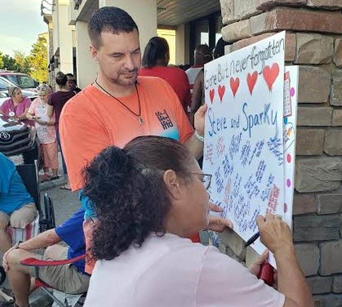 Fran Georgia, who used to play at Waccamaw Bingo, signs a card held by Antonio Valintino for the parlor’s two owners who were killed during an attempted armed robbery on July 26. The shooting was reported around 9:45 p.m. on July 26.