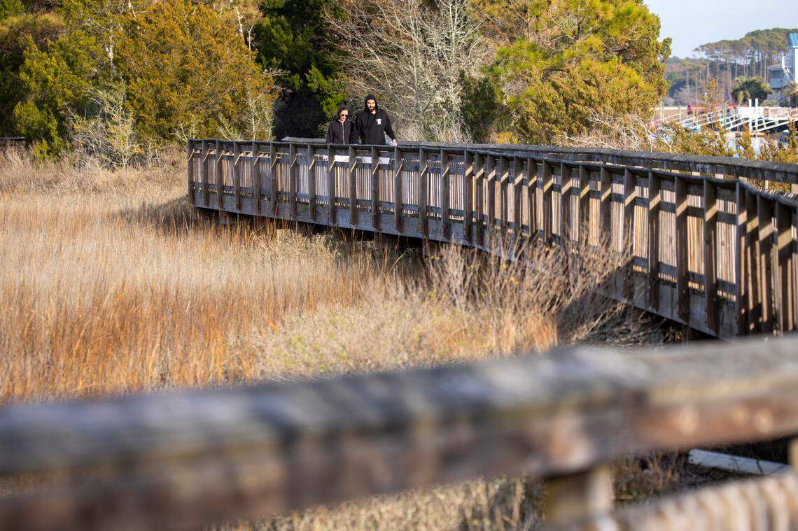 Visitors to the Heritage Shores Nature Preserve walk one of the elevated boardwalks over the marsh at Hog Inlet in North Myrtle Beach on January 11, 2023.