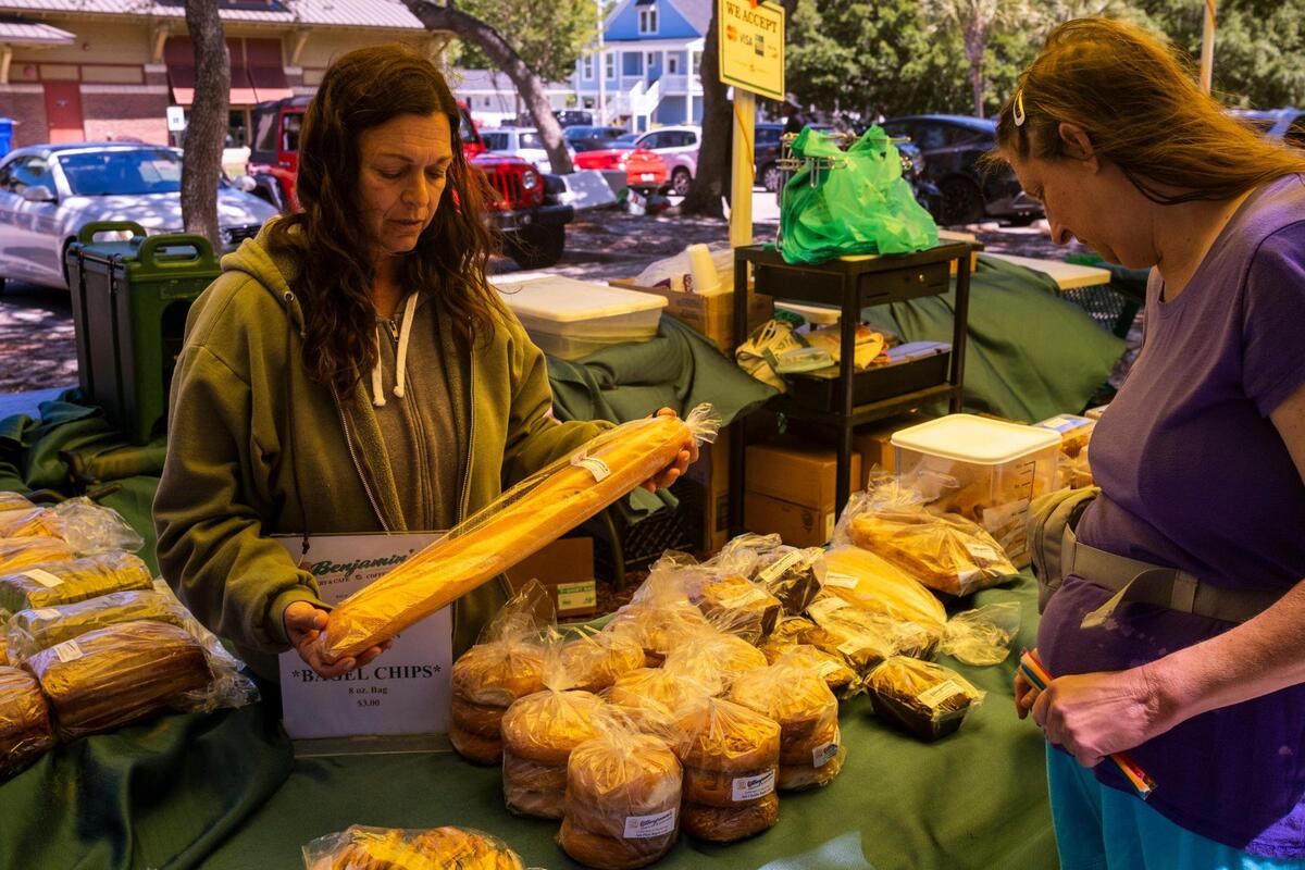 Bernadette Terrana of Benjamin’s Bakery and Cafe offers baked goods to customers at the The Surfside Beach Farmers Market. Part of the Waccamaw Market Cooperative, the Surfside market is held every Tuesday from 10am-3pm from April through the October with farmers, artisans, bakers and chefs selling locally produced goods. The cooperative hosts seven markets around the Grand Strand. May 10, 2022.