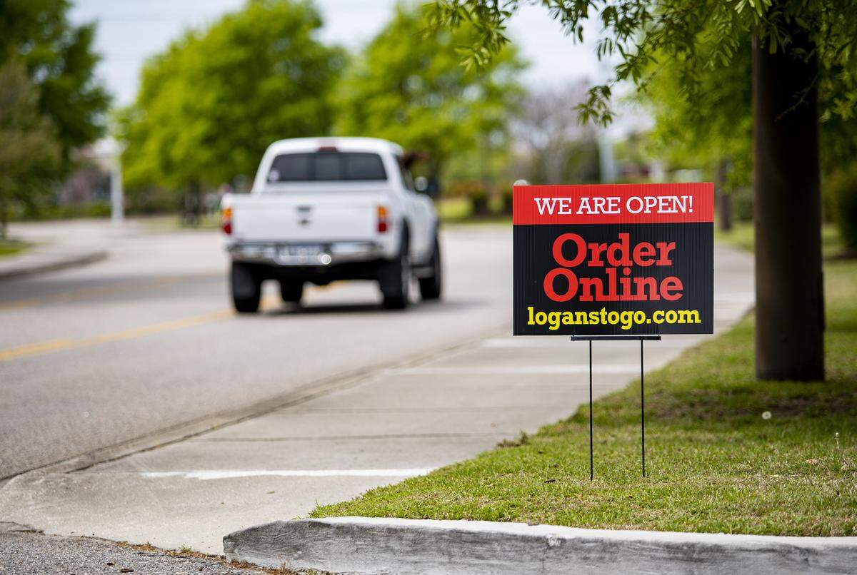 A sign advertising Logan’s Roadhouse in Myrtle Beach, which is providing curbside to-go orders.