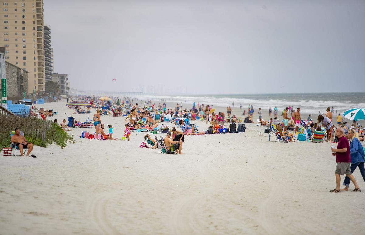 Garden City visitors and residents sit along the beach in Garden City Saturday afternoon. The number of coronavirus cases in Horry County and the Myrtle Beach area continued to rise Saturday, with three additional cases. The county’s total rose to 201 cases, up from 198 on Friday, according to the South Carolina Department of Health and Environmental Control.