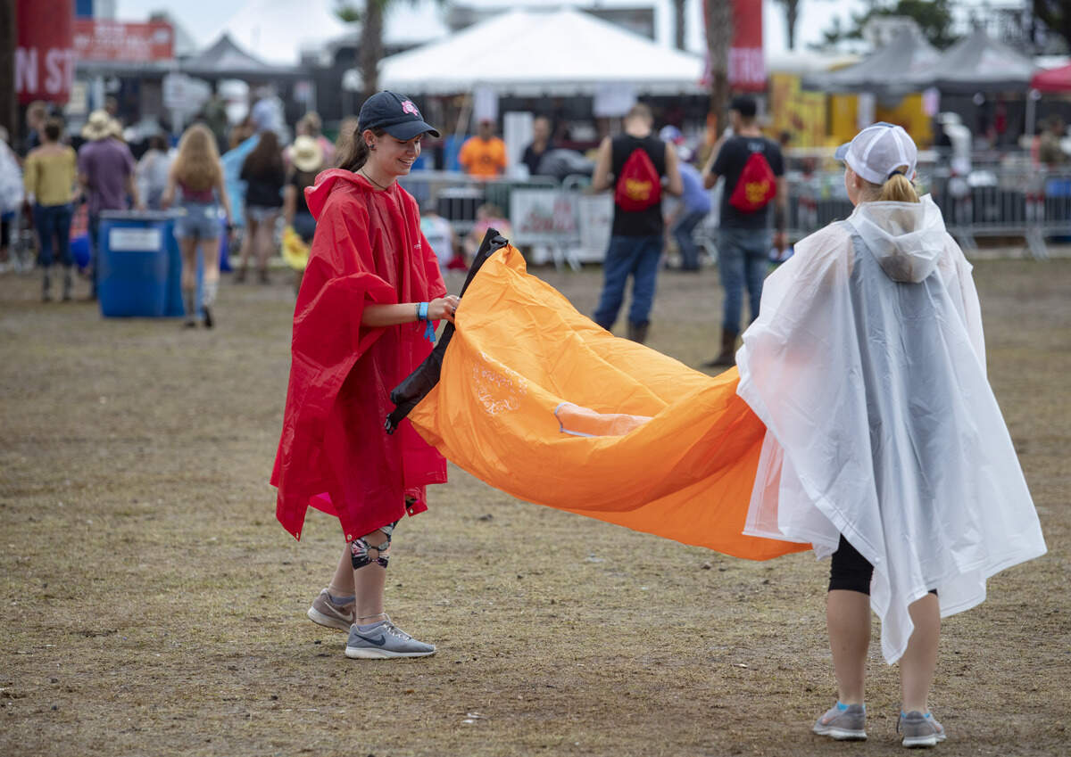 Blythe Morris (L) and Laney Atkinson of Morehead City, N.C try to fill their air sofa Saturday afternoon at Carolina Country Music Fest in Myrtle Beach.