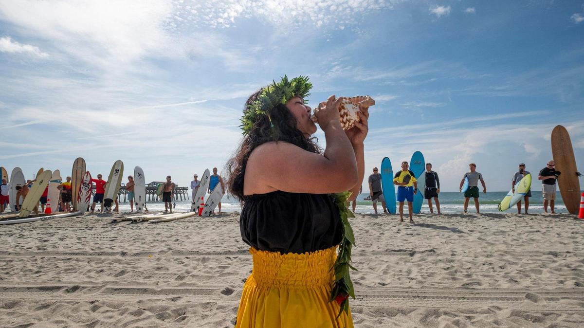 A member of the Ohana Kahakai dance group blows a conch shell as part of a paddle out ceremony and celebration of life for Lt. Matthew A. Piontkowski who died of cancer on June 9, 2023. Fellow firefighters, police officers, friends and family joined in the traditional ceremony that was held on the beah in Garden City. July 15, 2023.