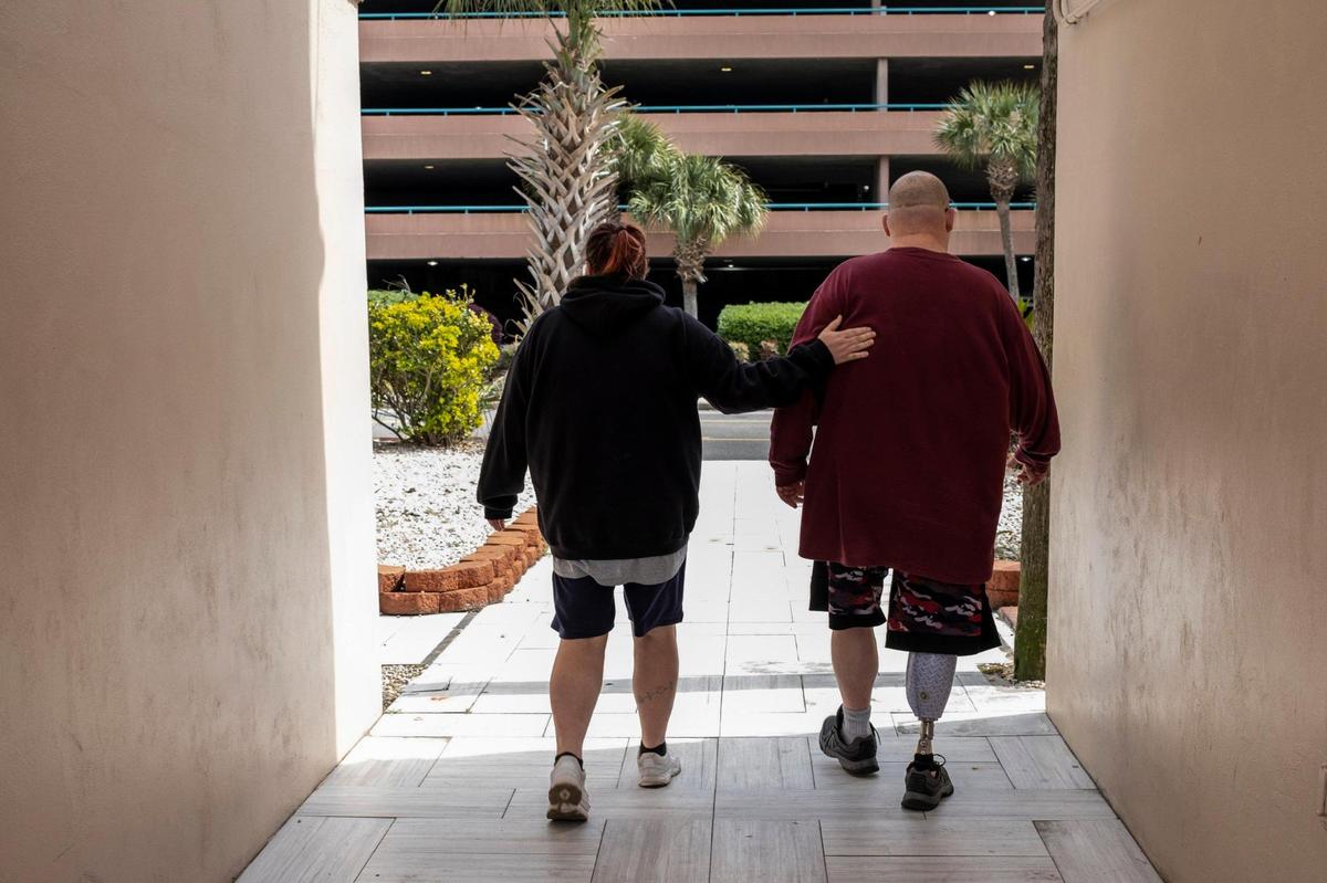 Leslie Mullins walks to the courtyard of the Pace II apartments in Myrtle Beach with her husband James who is disabled. The couple say they will have no where to go if evicted from their until next month due to a business license violation. The former Sea Banks and Rosen Sea motels in Myrtle Beach were converted into multi-family affordable housing units more than a year ago, but has been operating with a business license that only allows short-term rentals. A judge determined that the business is operating illegally and has ordered the owner to immediately remove all tenants. Many of the more than 100 residents are on rental assistance say they have no where to go but have been given notice that they need to be out by April 17th, 2023.