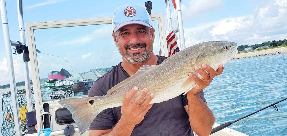 Al Almarzouqi poses for a photo while holding a fish during a trip out on his boat.