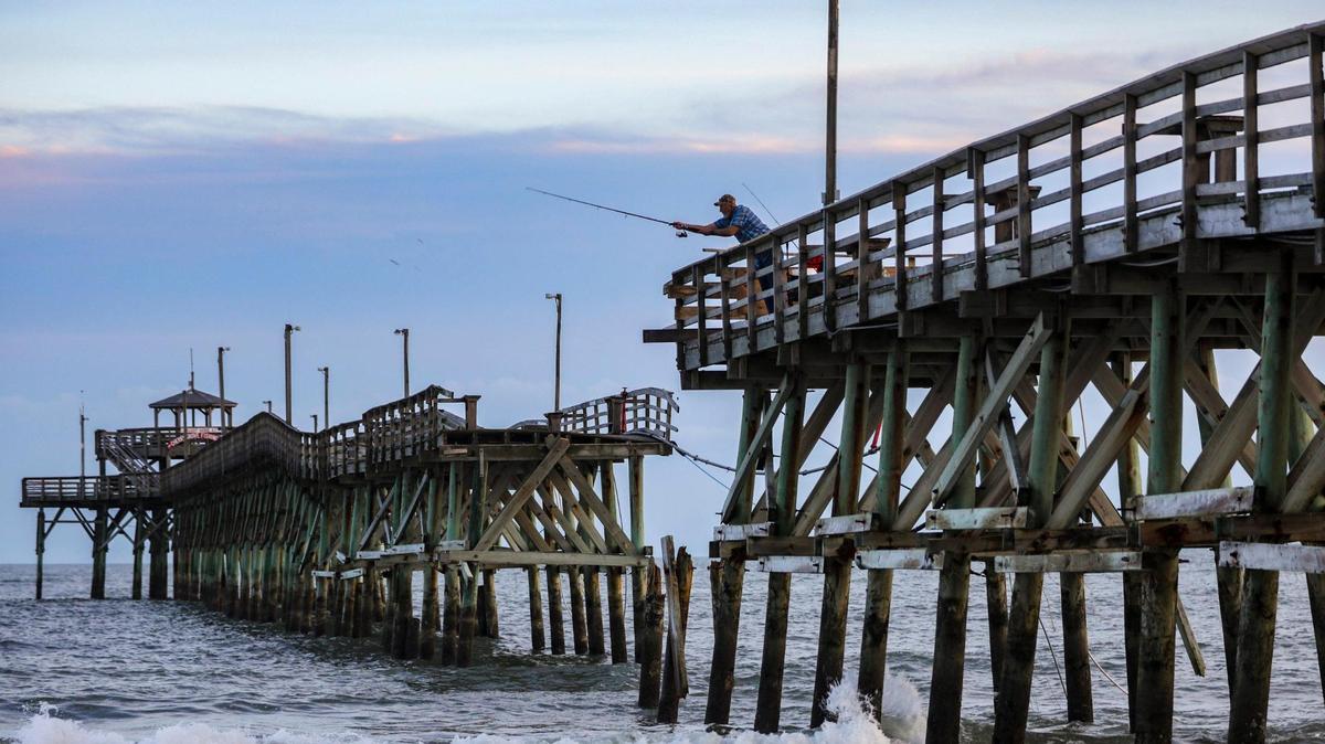 A fisherman casts from the broken Cherry Grove Pier in North Myrtle Beach, S.C. Myrtle Beach area piers took a battering from Hurricane Ian in 2022.