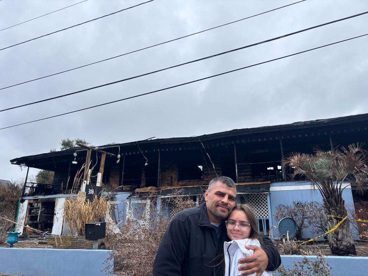 Michael and Adrienne Reinard pose in front of Atlantic Sands apartment complex. The Reinards used to live here before the building caught on fire on Christmas Day 2024.