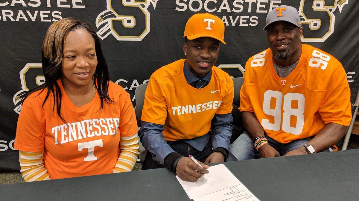 Kenney Solomon II (center), poses for a photo with his father and mother, Kendra, during his signing day ceremony at Socastee High School. He committed to play defensive back at the University of Tennessee.