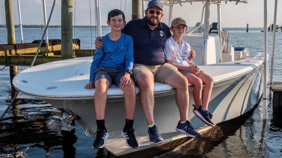 Mark Smith and his sons, Jack (12) and Cullen (10) aboard their boat, “Wound Tight” that has served as refuge since their mother Emily Smith died of Glioblastoma cancer. The Smith’s have set up a foundation called Emily’s House to give other’s suffering from cancer a place to vacation. Georgetown , S.C. October 16, 2020.