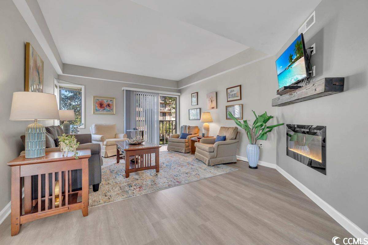 The living room which includes the gas fireplace and a television. There is ample seating available.