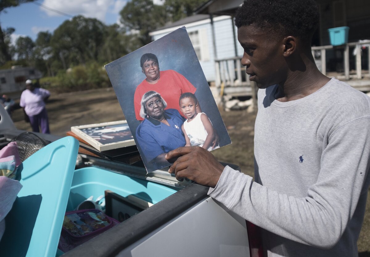 Blake McCray collects family pictures from his flooded home off Martin Luther Rd. in Bucksport trying to prevent important memories from being spoiled by the moisture. Flooding along Bucksport Road finally receded enough on Wednesday for residents to get a first look at their flooded homes. Wednesday. October 3, 2018.