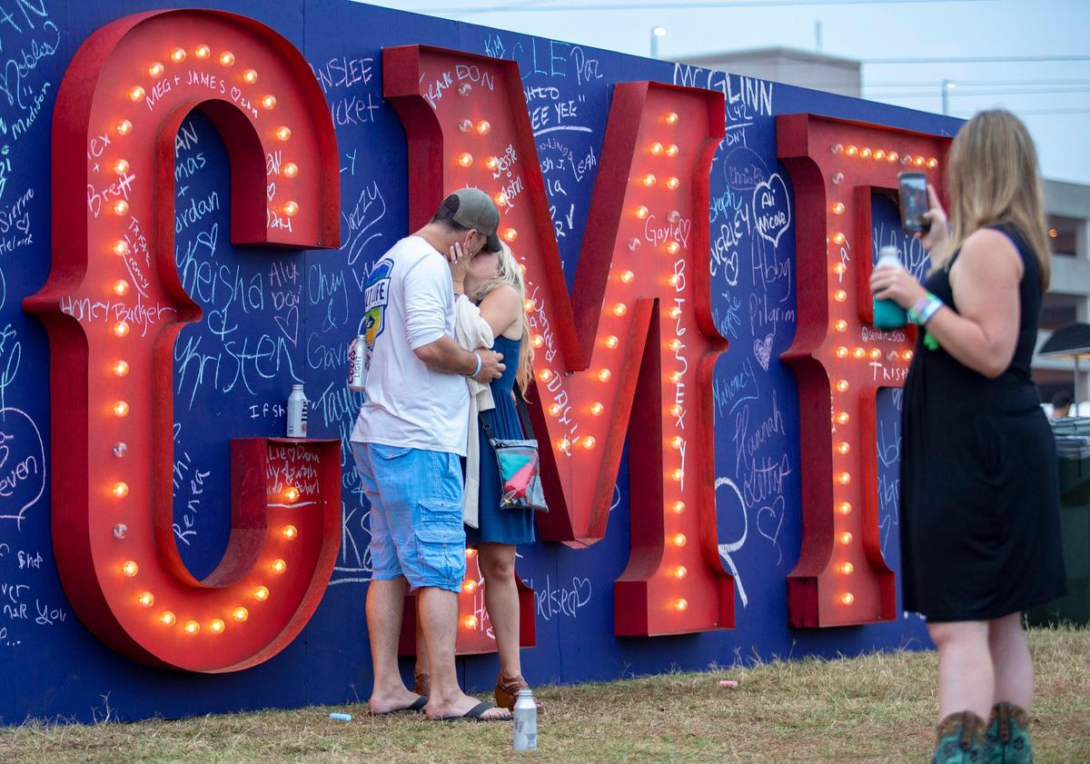 David Allen of Charleston, S.C., kisses his fiancée, Julie Hatfield, also of Charleston, moments after proposing to her in front of the CCMF sign wall at Carolina Country Music Festival in Myrtle Beach Thursday afternoon.