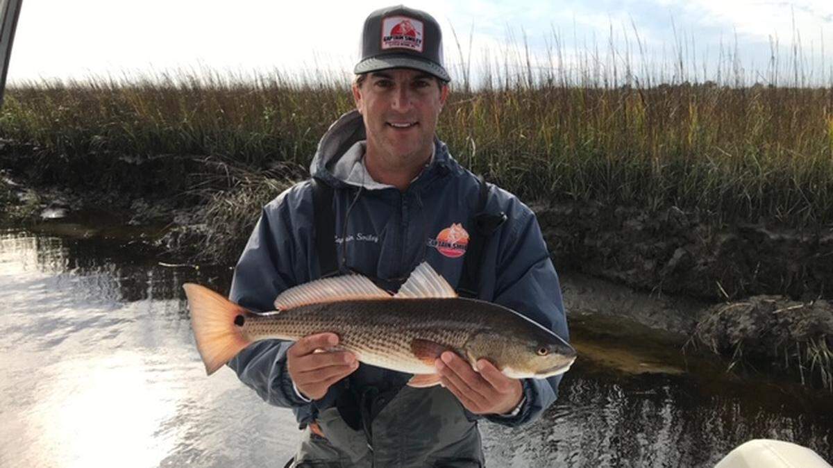 Capt. Patrick Kelly of Captain Smiley Fishing Charters shows off a red drum he caught Tuesday in the Little River vicinity.