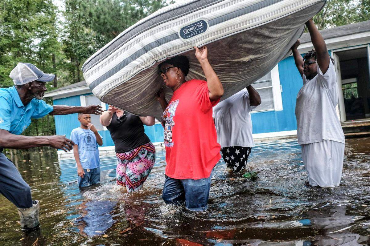 The Williams family off Collins Road in Longs, S.C. rapidly removes their belongings trying to keep their mattresses dry. Water began flooding the small community of Longs, SC late in the week touching some homes that did not expect to suffer the flood’s wrath. September 21, 2018.