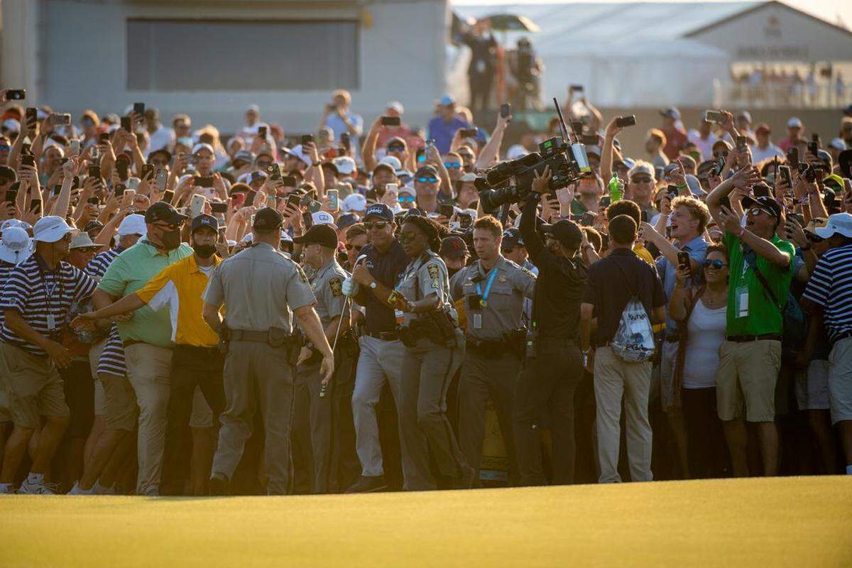 Phil Mickelson emerges from a throng of spectators who rushed the course near the 18th green Sunday during the final round of the 2021 PGA Championship at Kiawah Island Golf Club’s Ocean Course. May 23, 2021