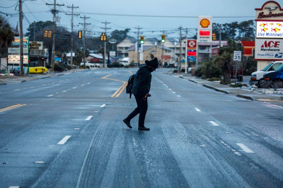 A worker carefully crosses Sea Mountain Highway on Saturday morning. A rare winter storm struck the Grand Strand area on Friday, Jan. 21st and Saturday Jan. 22, 2022 coating everything in the region with a glaze of ice. Jan. 22, 2022.