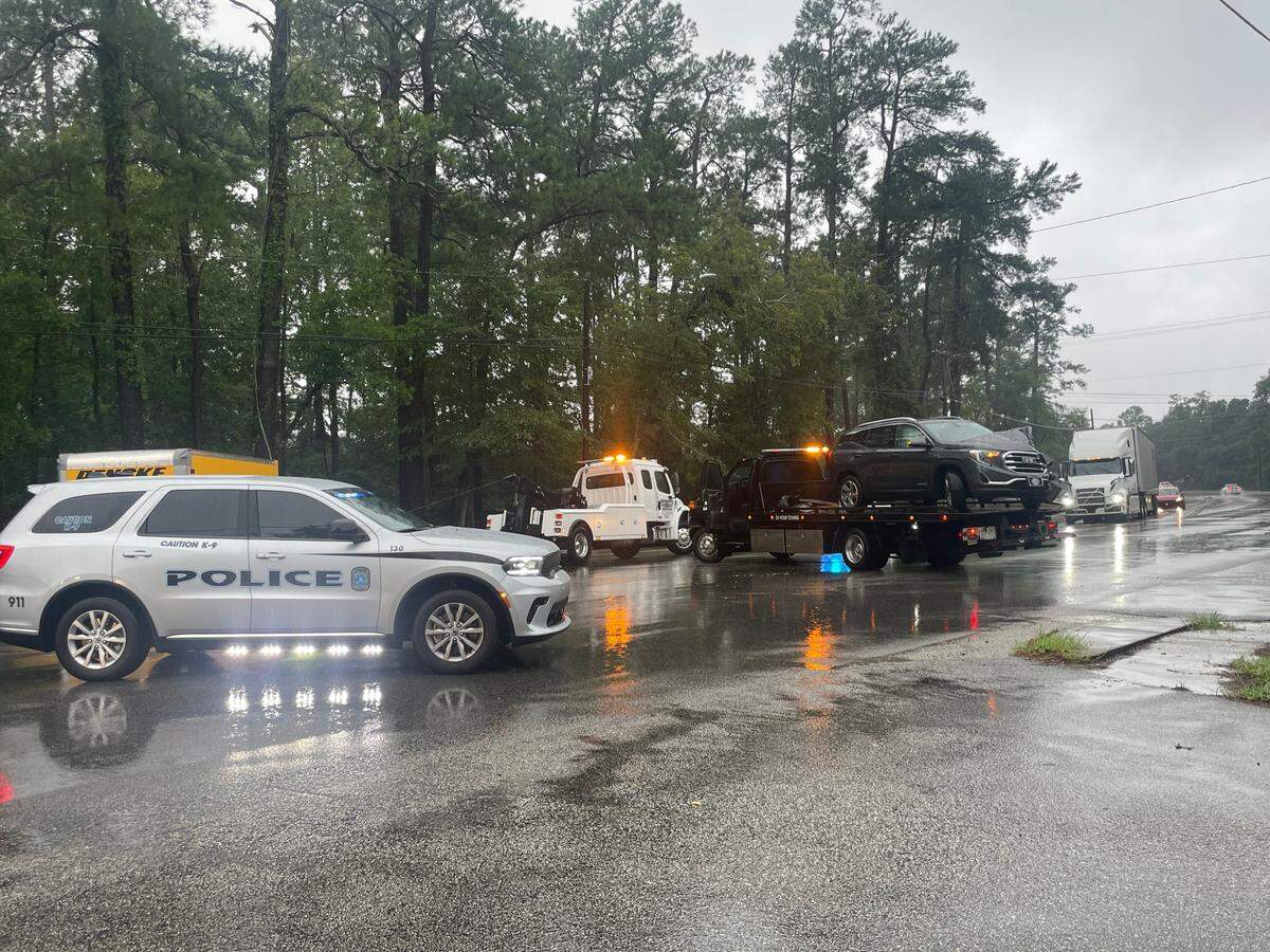 Police and tow trucks clear a car accident near Conway, SC, as Tropical Storm Debby pours rain on the Grand Strand.