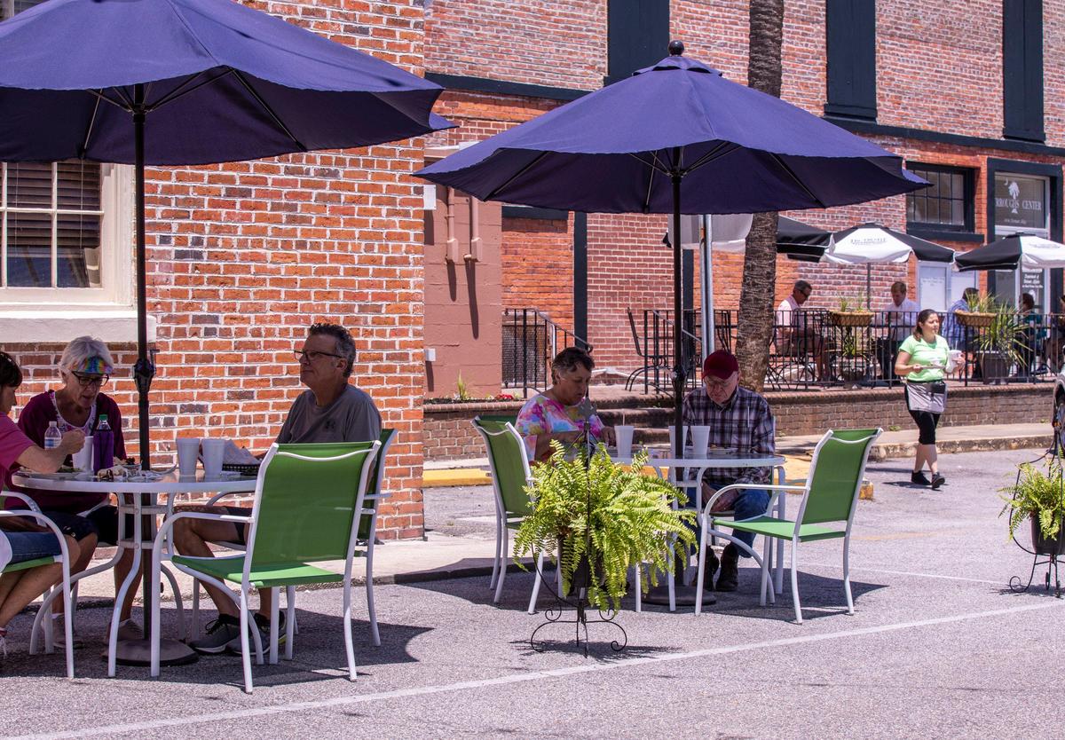 Diners eat at outdoor tables set up by The Trestle in Conway’s Norman Ally. The City of Conway is doing what it can to help its restaurants recover from coronavirus emergency closures. May 6, 2020