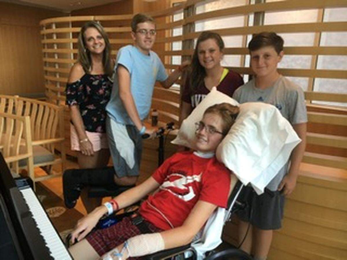Jack Boldt (second from left) and Luke Boldt (in chair) with family during their recovery from a car crash that occurred in July 2017.