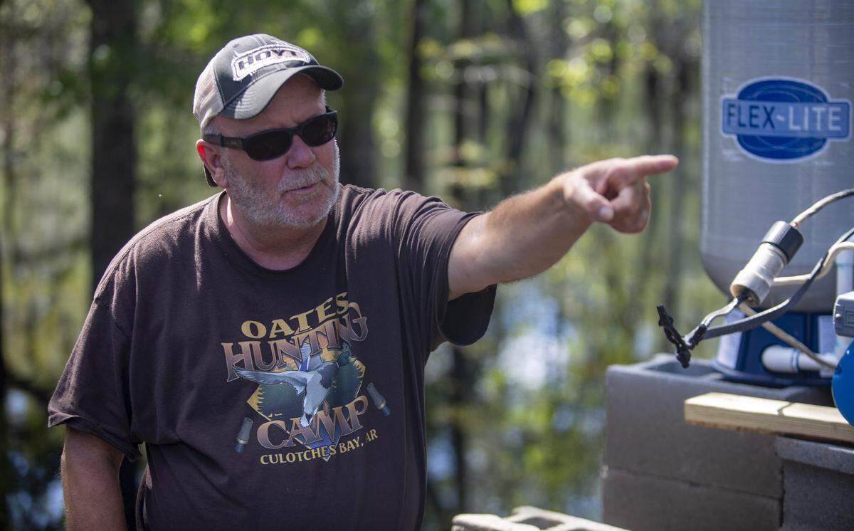 Gallivants Ferry resident Robert Ambrose points out damage done to his home over to his home Tuesday as floodwaters began to recede in the area.