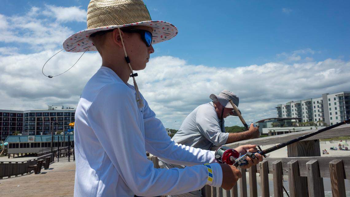 Sawyer Williamson fishes with his grandfather Mike Williamson on the Springmaid Pier on July 2, 2024.