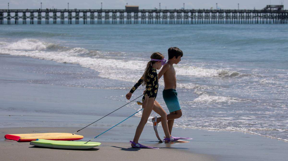 Kids head for the waves in front of the Apache pier at in the Arcadian Shores section of Horry County. The week of Memorial Day marks the unofficial beginning of the tourist season along Grand Strand Beaches. May 31, 2022.