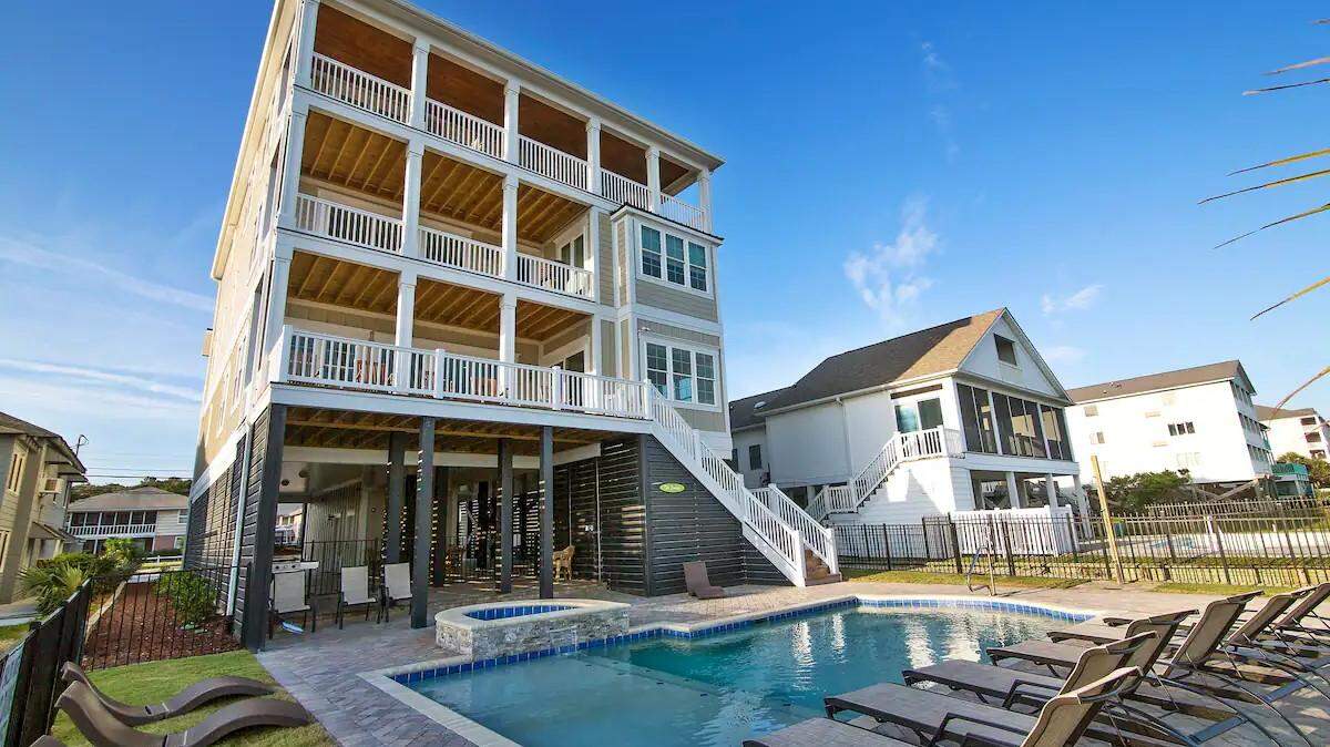 The backside of The Carlisle. It has a heated pool, hot tub and tons of outdoor seating. The part of the house is facing the Atlantic Ocean.