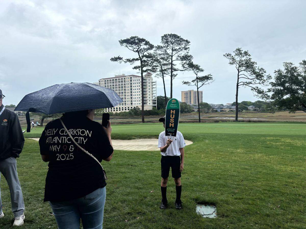 Ashley Thompkins takes a photo on Sunday of her son Austin Rhodes holding the “Hush” sign. Thompkins brought Rhodes to the Myrtle Beach Classic PGA Tournament for Mother’s Day.