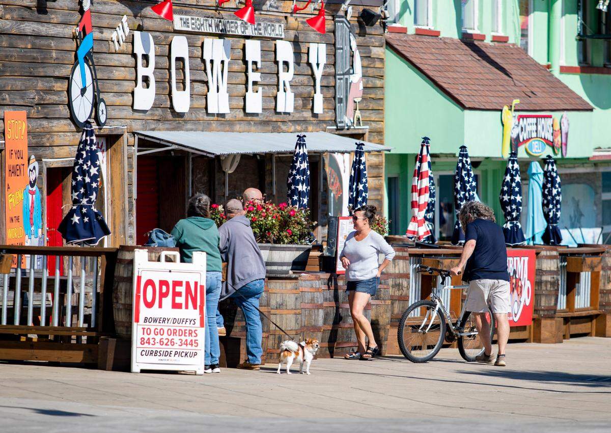 People chat outside The Bowery at 9th Avenue North and Ocean Boulevard where the band Alabama is said to have got their start. 2020 File Photo.