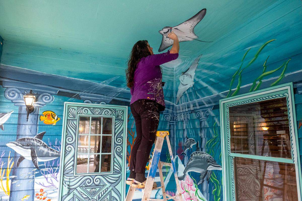 April Bensch puts the finishing touches on a series of murals at Crab Daddy’s Calabash seafood. The murals, painted by April Bensch at restaurants along the Grand Strand are often humorous and whimsical. October 28, 2022.
