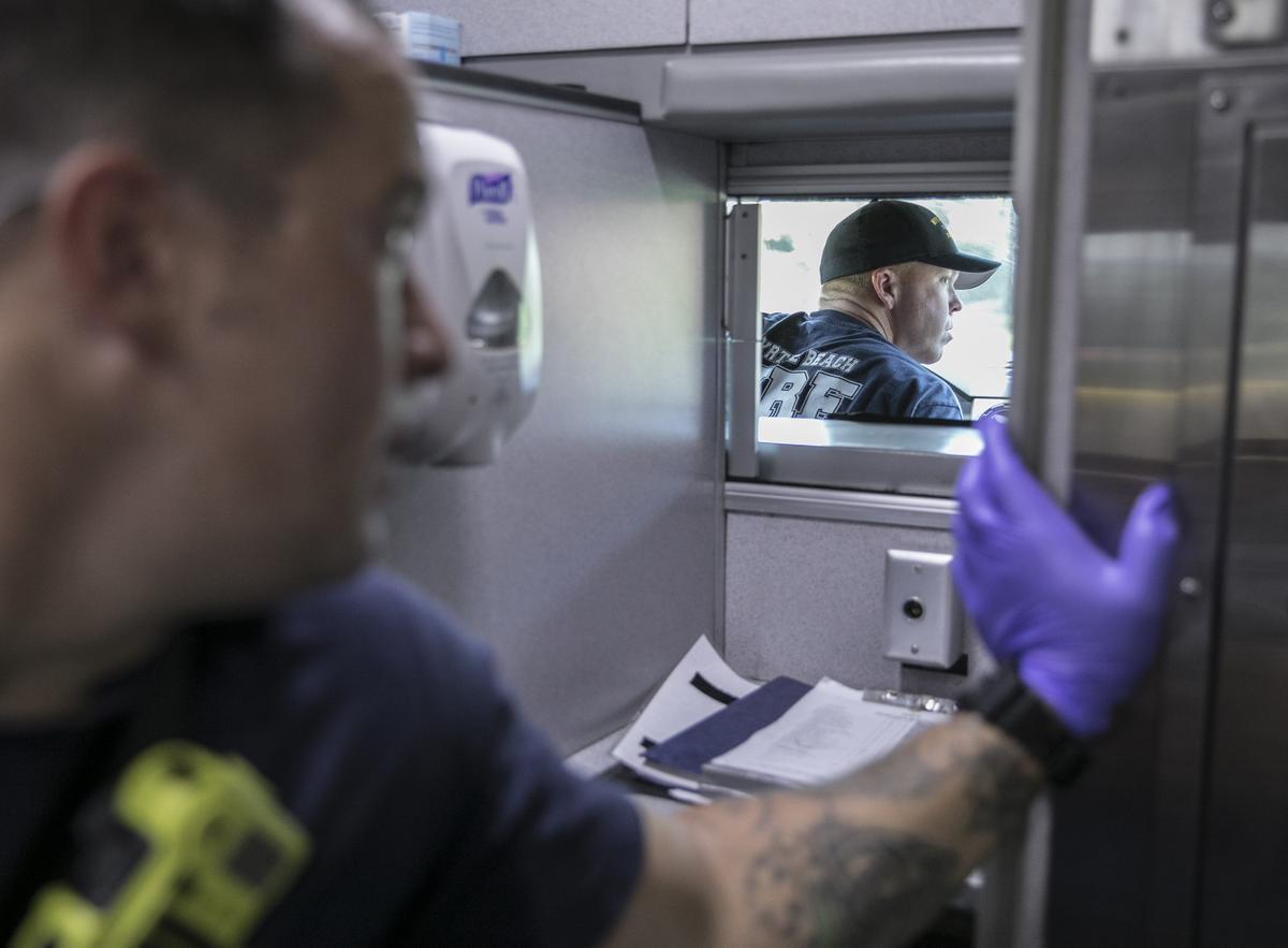 Joshua McCarthy, probationary firefighter/paramedic, shouts to Paramedic Ross Porter from the back of an ambulance as Porter drives to a call in Myrtle Beach. Porter has served the Myrtle Beach Fire Rescue for 10 years. Aug. 7, 2018.
